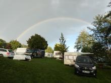 Duha nad karavany, kolem kterých se k vodě za chvíli nedostaneme.